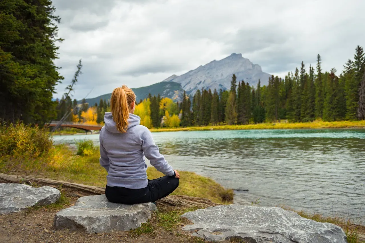 Woman practicing meditatforion in a luch forest near a river on a rock | Picture by Magic K: https://www.pexels.com/de-de/foto/frau-entspannung-wald-fluss-6728220/