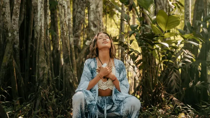 Yoga woman meditating in a lush jungle touching her heart | Picture by Franklin Santillan A.